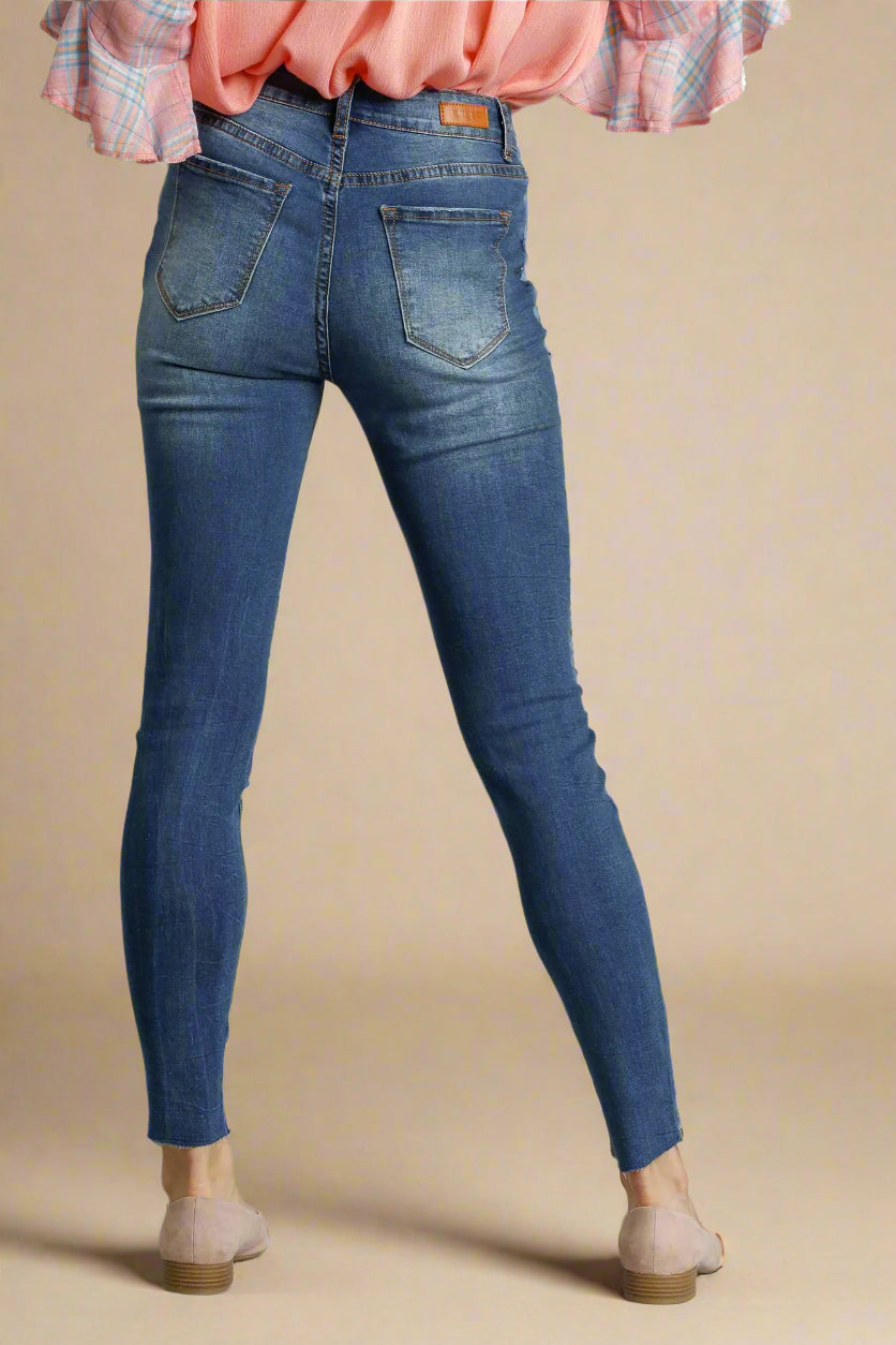 Blue jeans worn by a person on a beige background