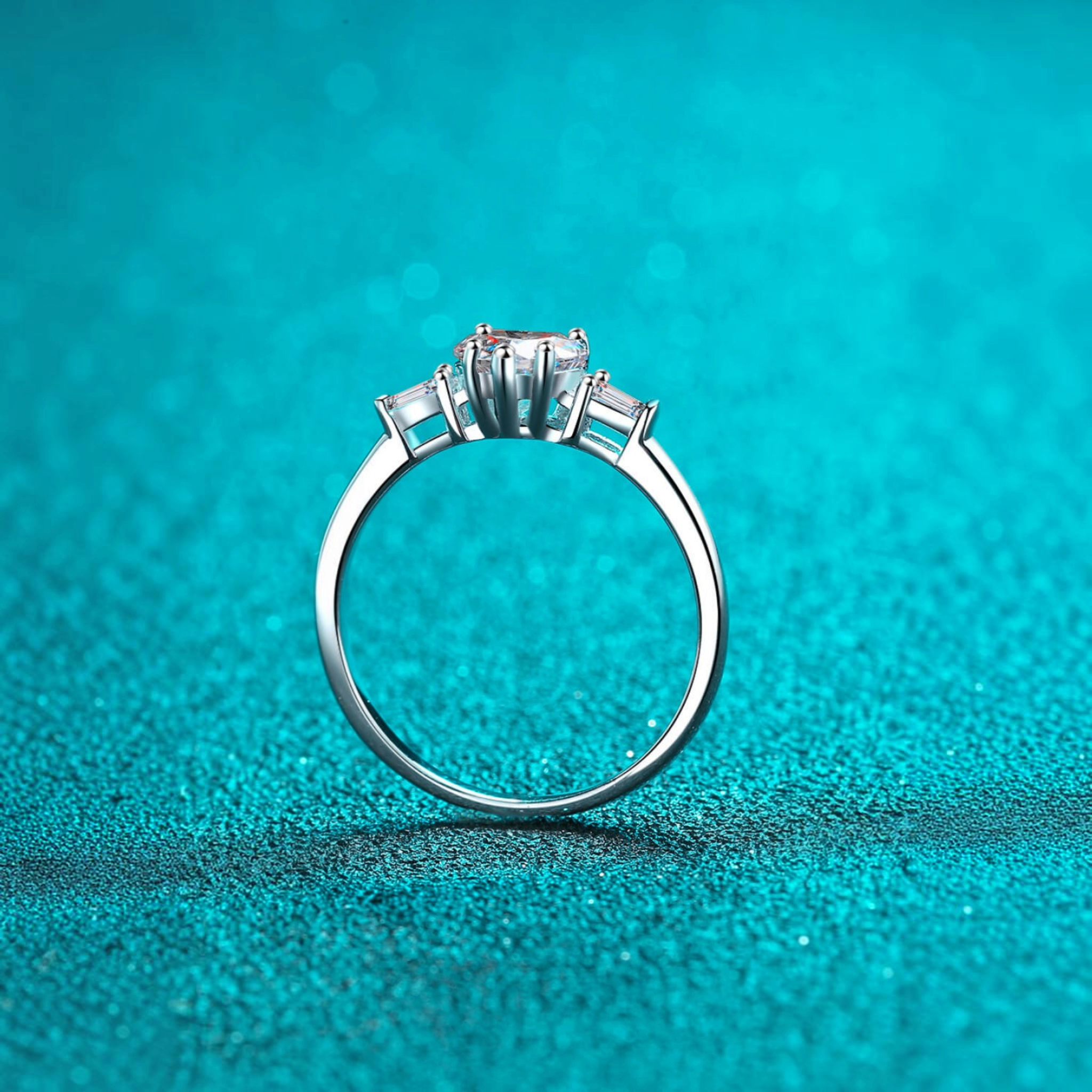 Beach Rose Co. sterling silver three-stone ring with a heart-shaped moissanite center and baguette side stones.