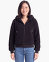 Beach Rose Co. black teddy fleece zip-up hooded jacket with a relaxed fit and ribbed cuffs worn with blue jeans.