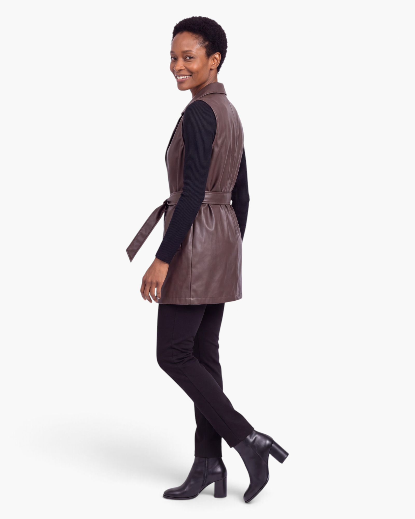 Beach Rose Co. brown faux leather longline vest with notched lapels and a matching waist tie worn over black clothes.