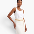 Beach Rose Co. adjustable gold-tone acrylic and aluminum curb chain belt worn over a white skirt.