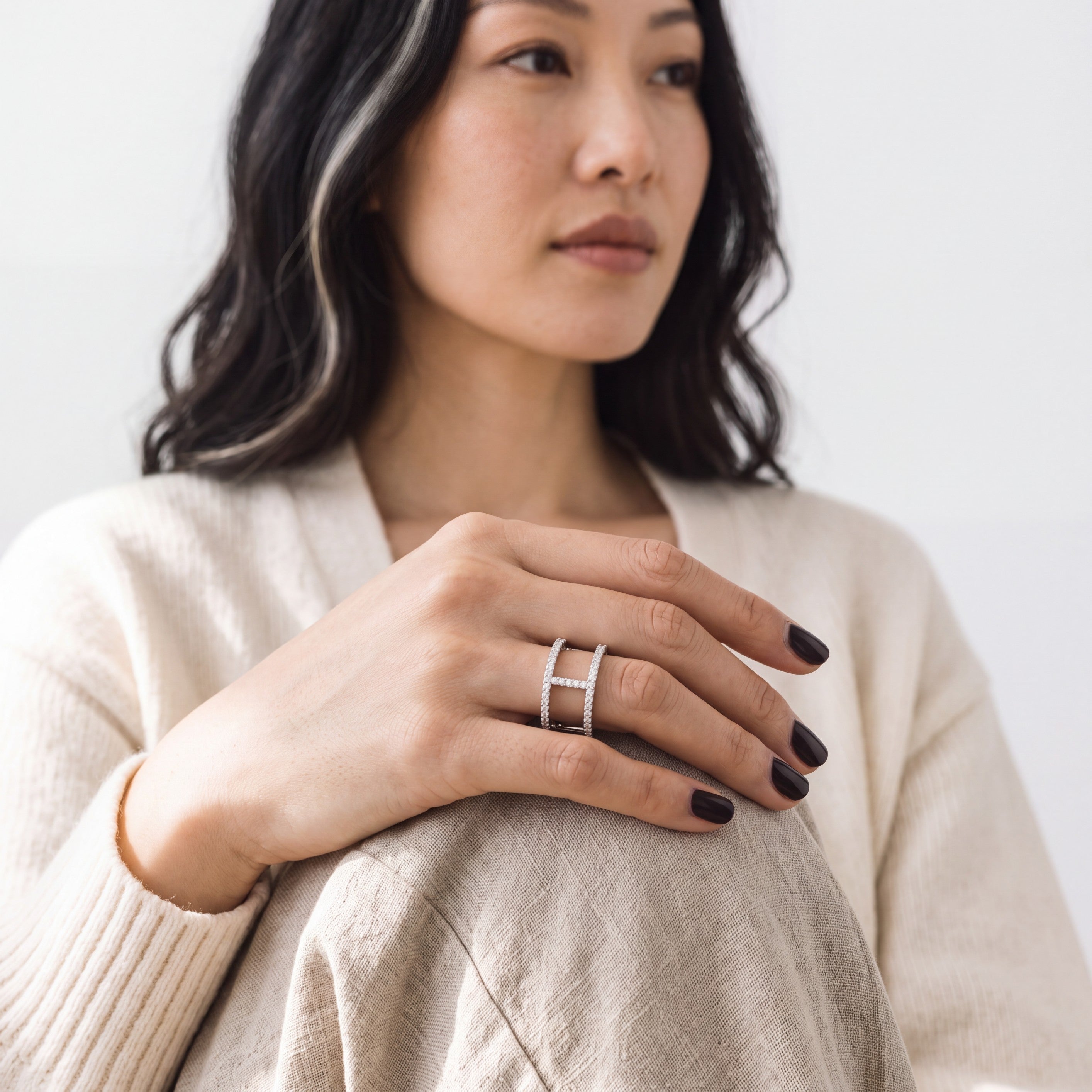 Beach Rose Co. sterling silver openwork ring with moissanite stones worn on a woman's finger.