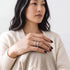 Beach Rose Co. sterling silver openwork ring with moissanite stones worn on a woman's finger.