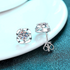 Beach Rose Co. sterling silver flower stud earrings featuring round moissanite stones with polished petal settings.