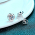 Beach Rose Co. sterling silver stud earrings featuring round moissanite stones in a polished swirl setting.