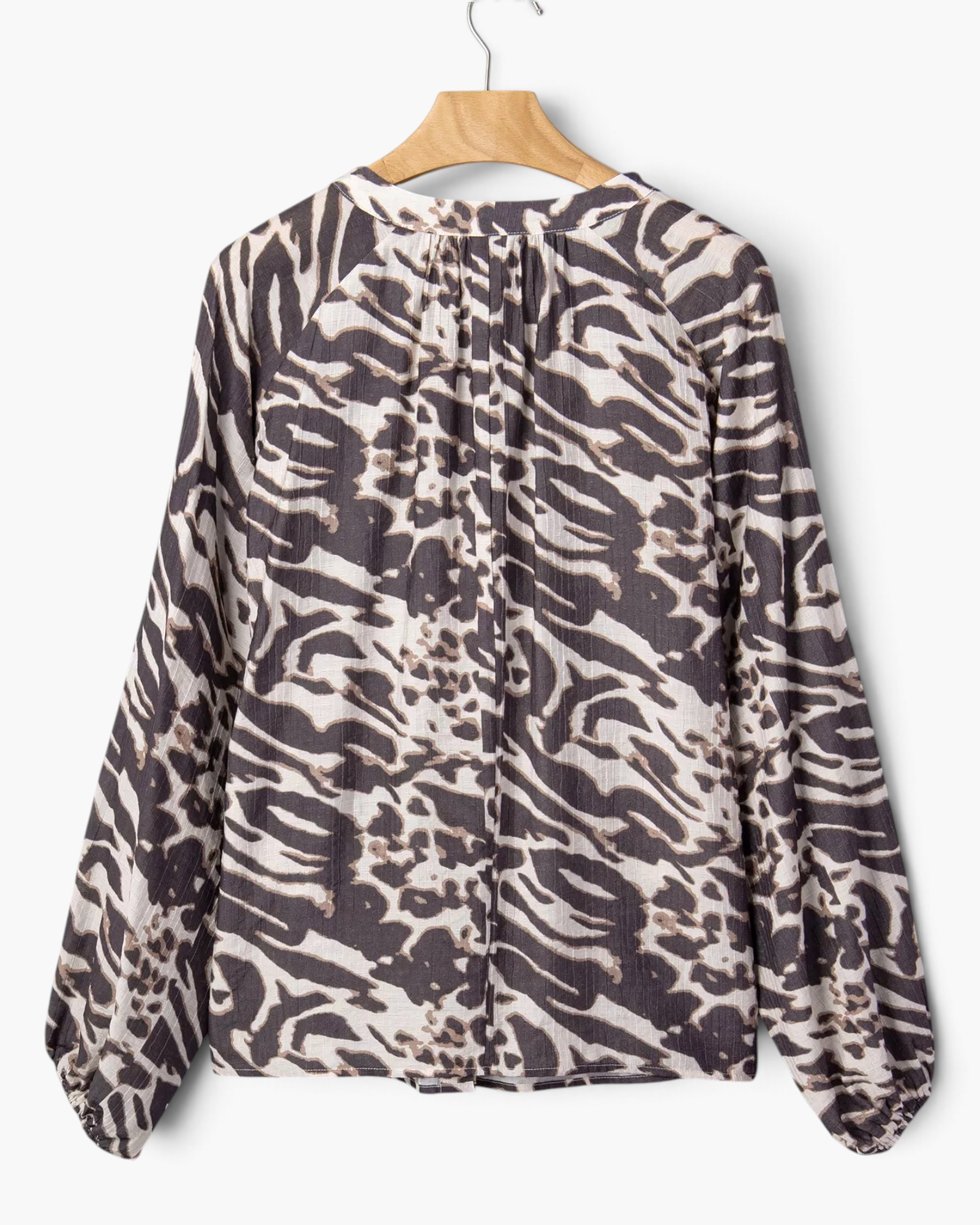 Beach Rose Co. charcoal and cream mixed animal print blouse with long raglan sleeves and a gathered back neckline.
