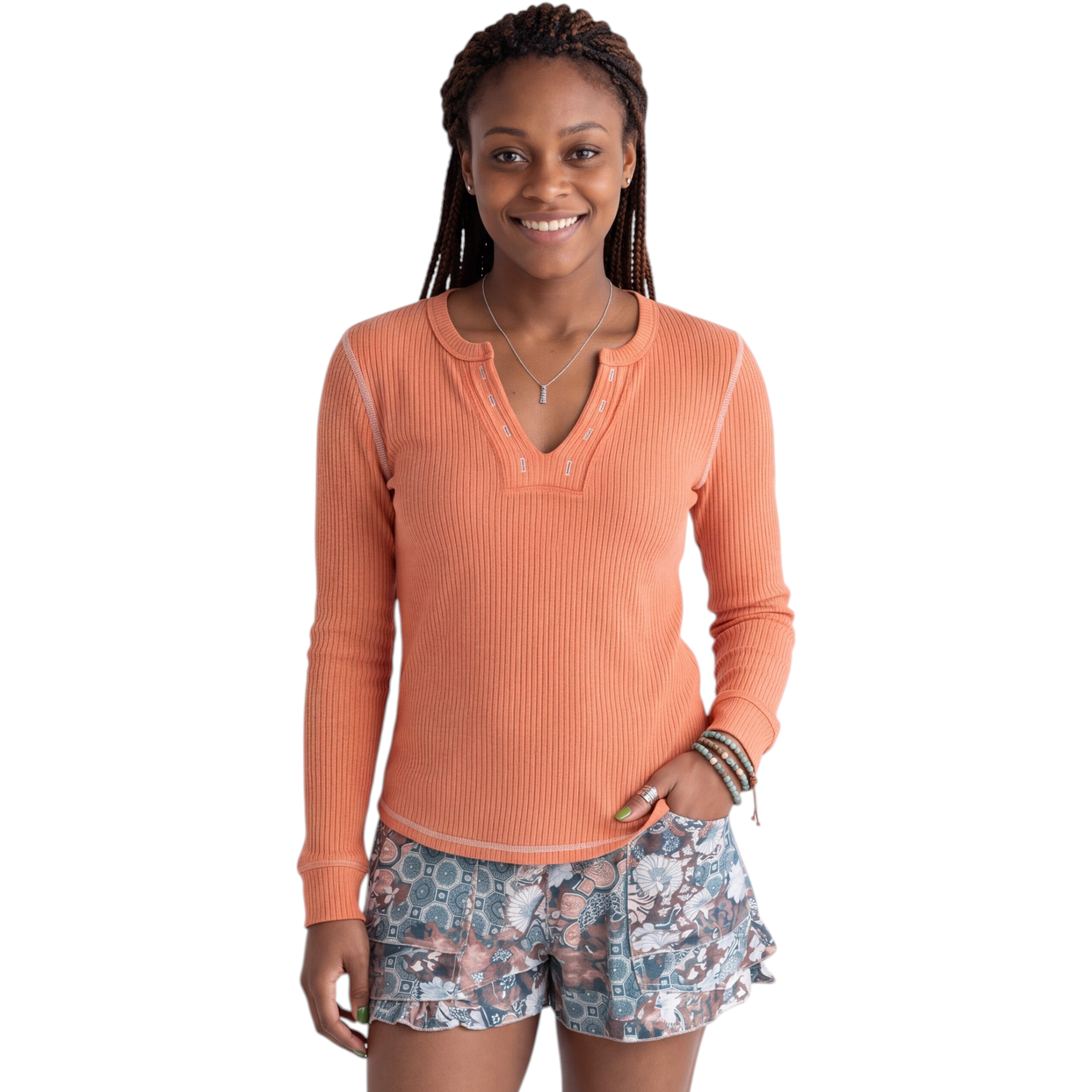 Beach Rose Co. coral ribbed long sleeve V-neck top with contrast stitching and cuffs worn with patterned shorts.