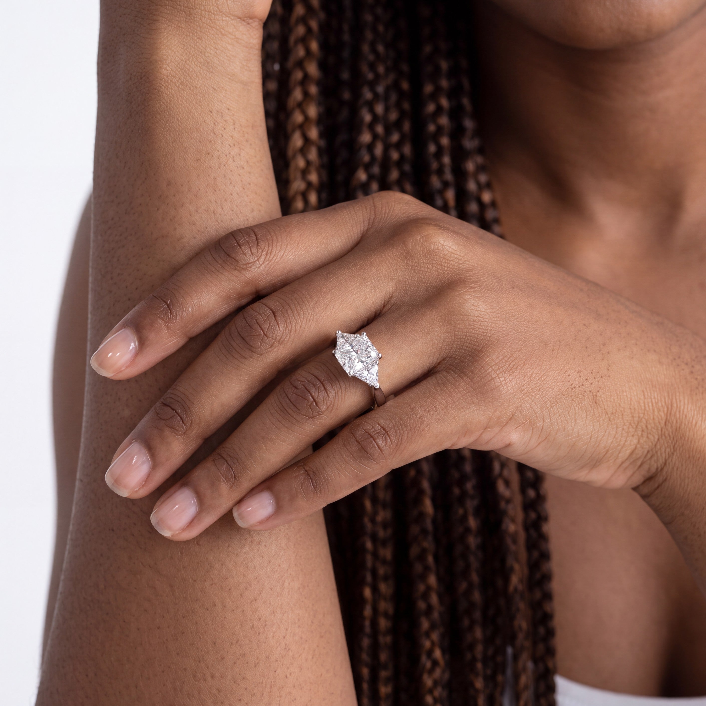 Beach Rose Co. 3 carat moissanite three-stone ring in rhodium-plated sterling silver on a woman's hand.