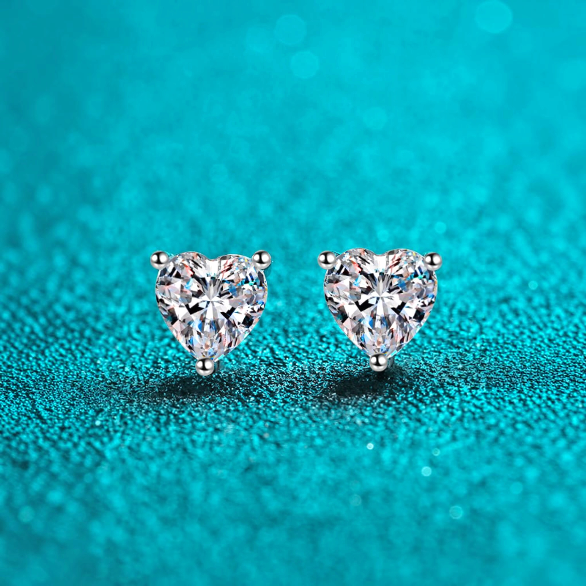 Beach Rose Co. heart-shaped moissanite stud earrings in rhodium-plated sterling silver with three-prong settings.