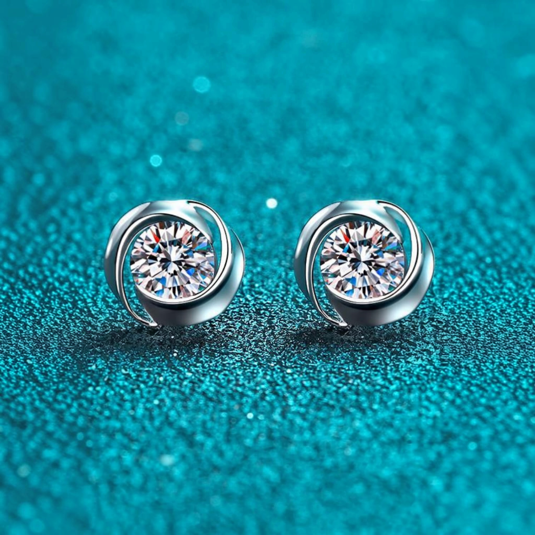Beach Rose Co. sterling silver stud earrings featuring round moissanite stones in a polished swirling setting.
