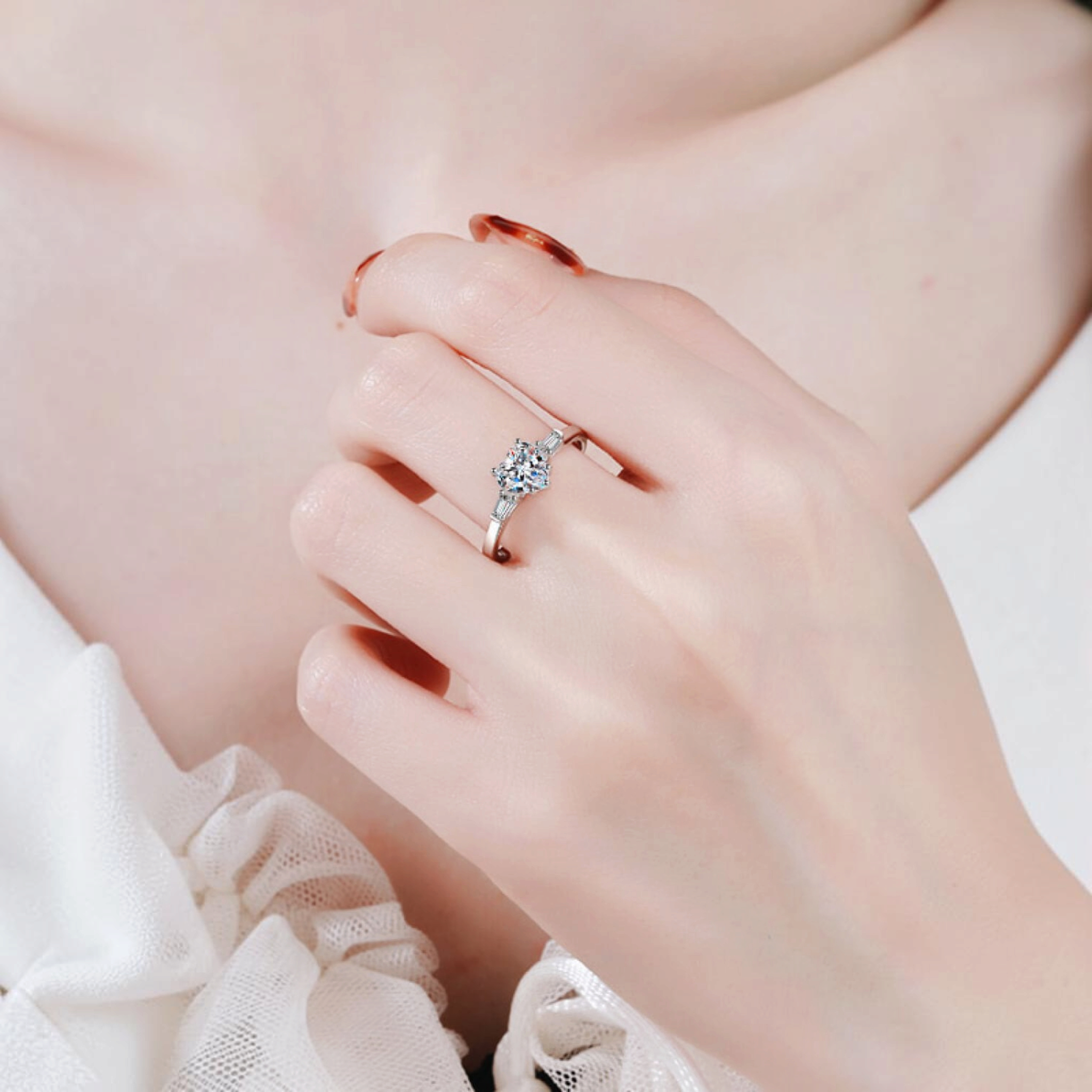 Beach Rose Co. sterling silver ring featuring a heart-shaped moissanite center stone and baguette side stones.