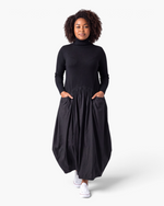 Beach Rose Co. black turtleneck maxi dress with a sweater bodice, gathered skirt, side pockets, and balloon hem.