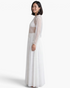 Beach Rose Co. white sheer mesh top with scattered sequins and long balloon sleeves worn with a matching maxi skirt.