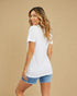 Woman wearing a white t-shirt and denim shorts on a beige background