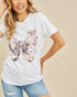 Woman wearing a white t-shirt with floral design on a beige background