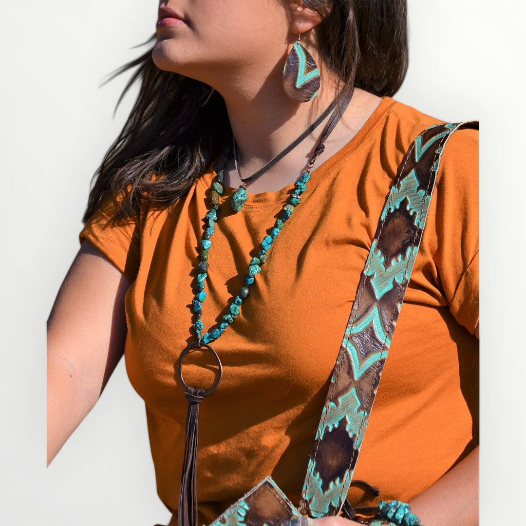 Person wearing an orange shirt with a decorative strap over shoulder