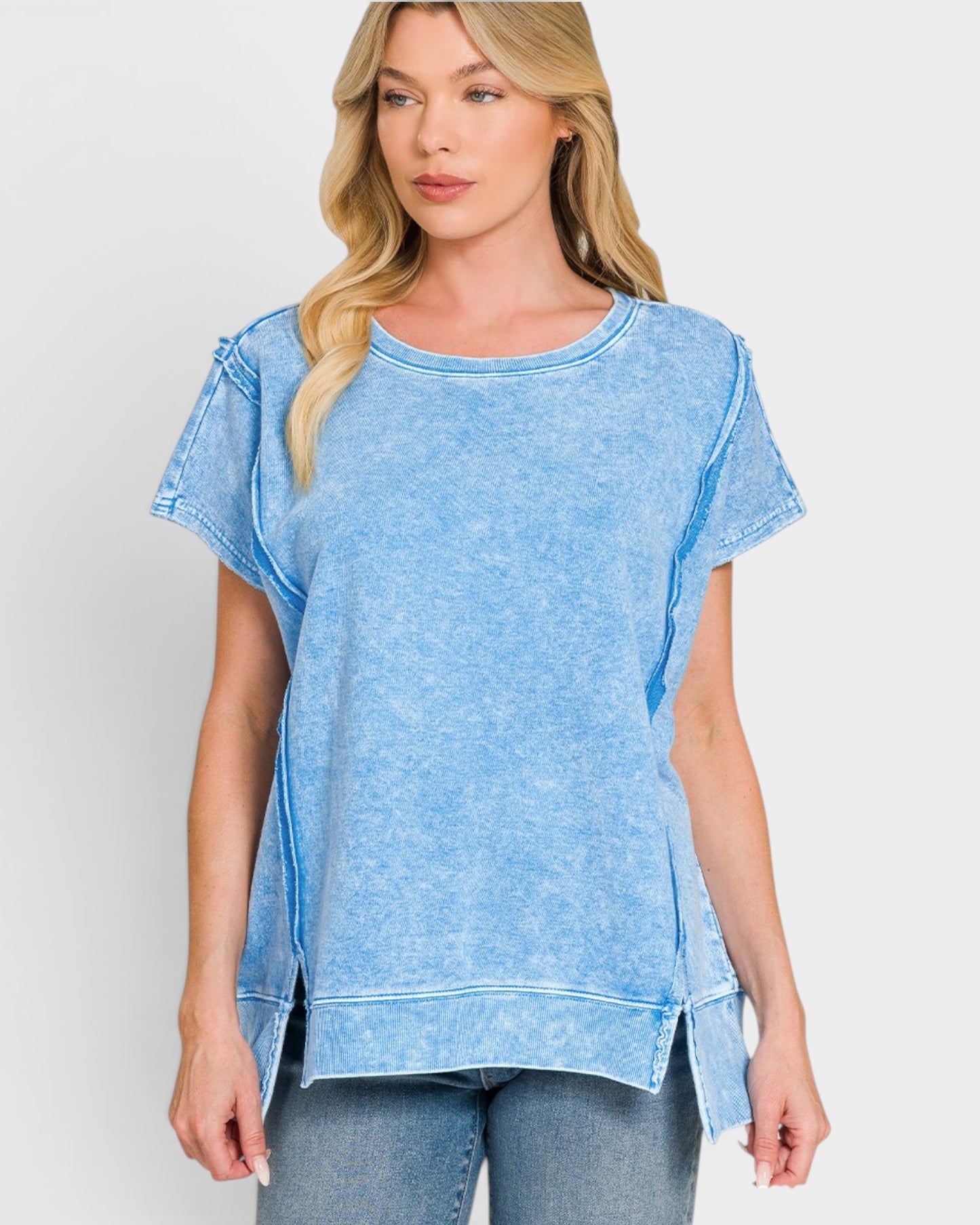 Woman wearing a blue distressed t-shirt against a white background