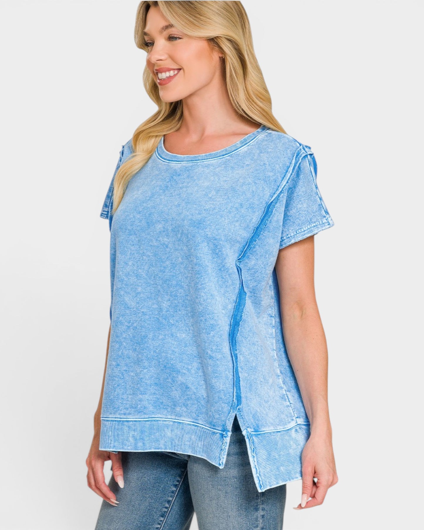 Woman wearing a blue denim-style top against a white background