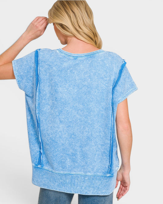 Woman wearing a blue tunic with a plain background