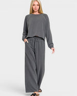 Woman wearing a gray lounge set on a white background