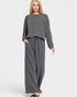 Woman wearing a gray lounge set on a white background