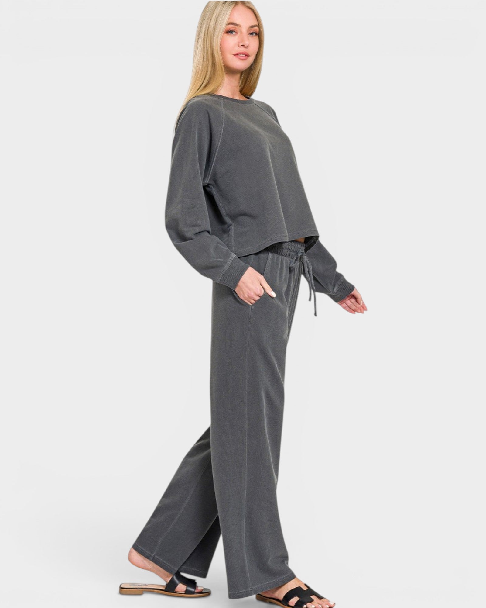 Woman wearing a gray sweatshirt and pants on a white background
