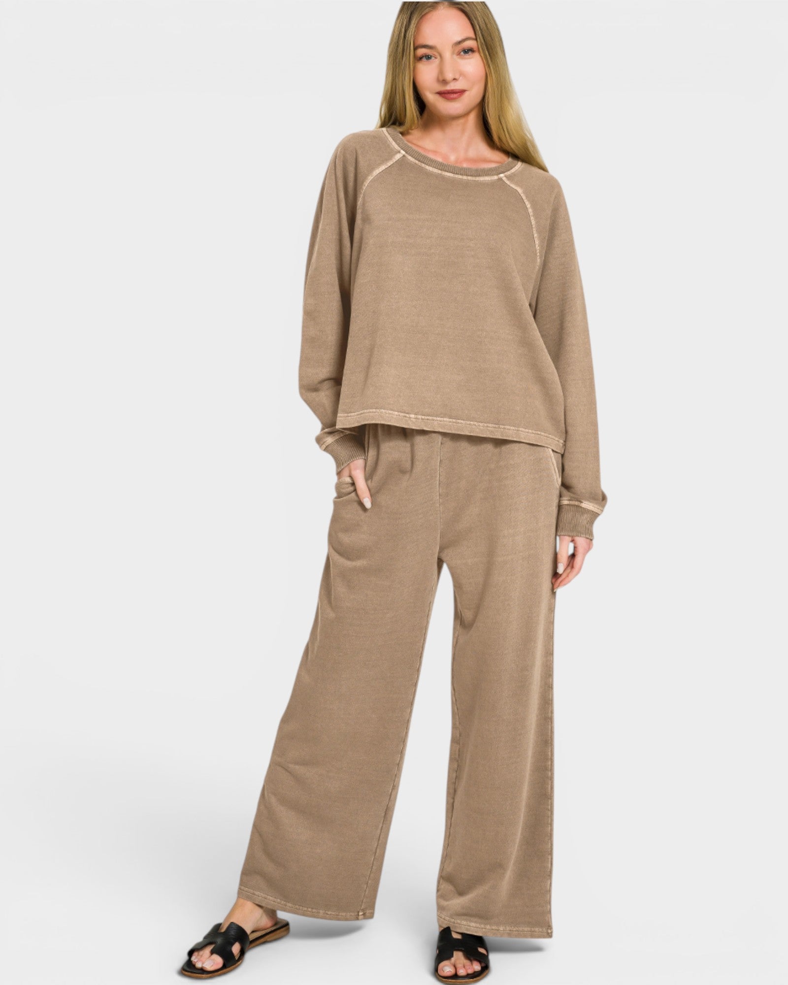 Woman wearing a beige lounge set on a white background