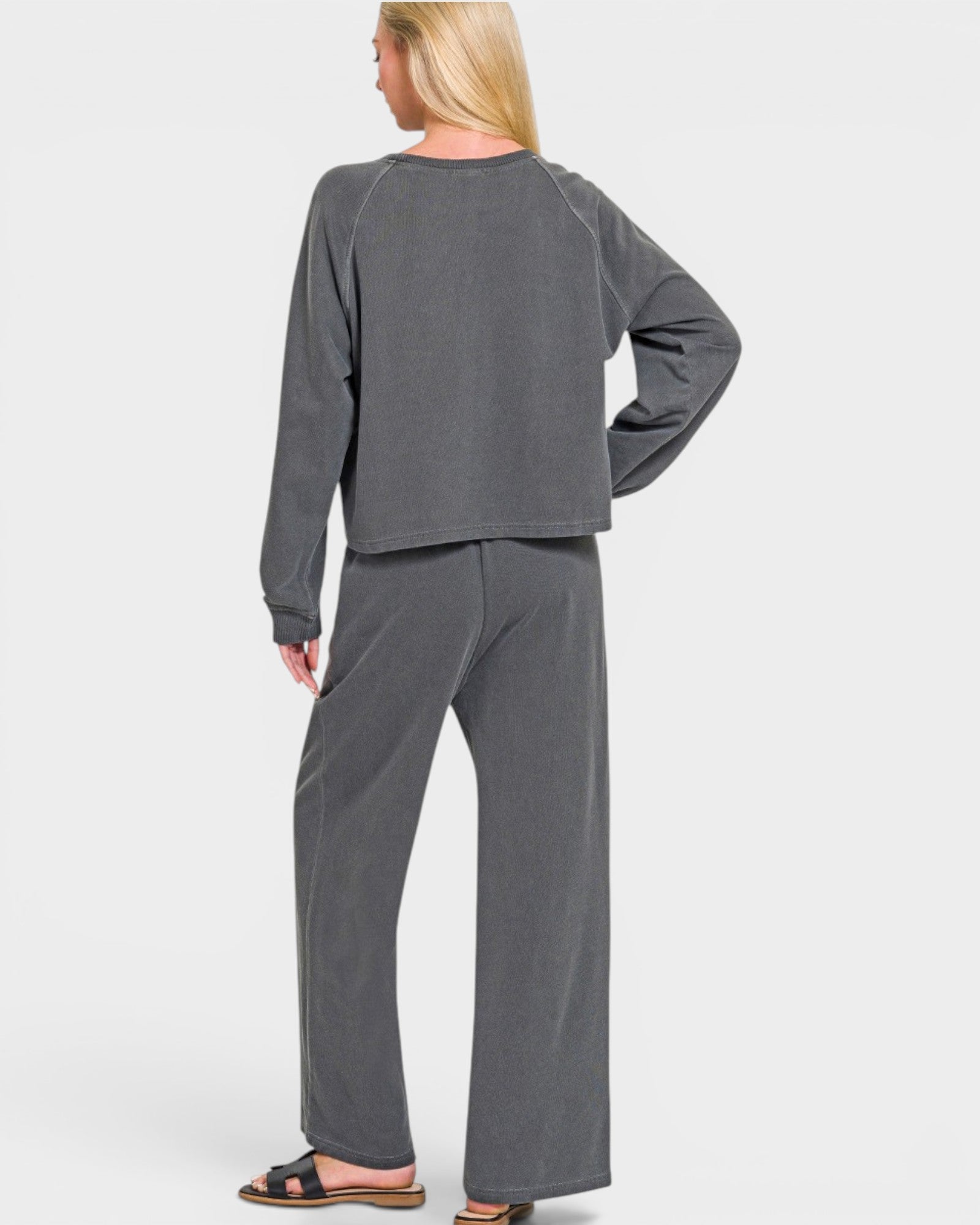 Person wearing a gray lounge set on a white background