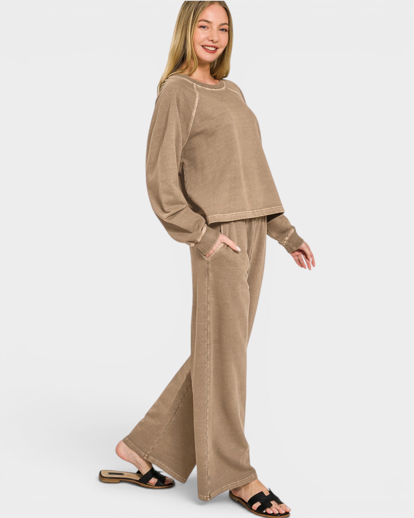 Woman wearing a beige outfit with wide-leg pants on a white background