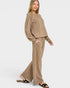Woman wearing a beige outfit with wide-leg pants on a white background