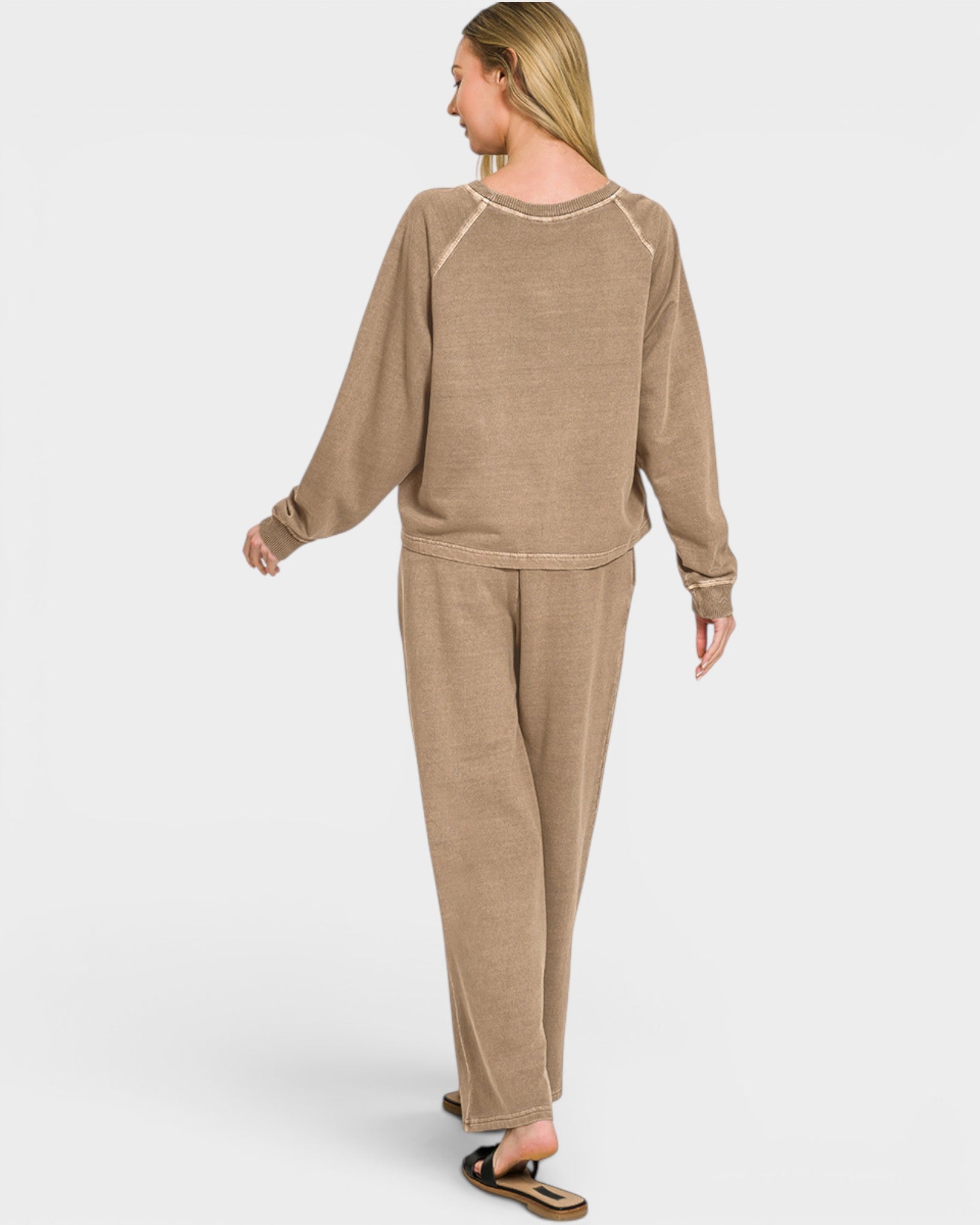 Woman wearing a beige lounge set on a white background