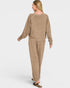 Woman wearing a beige lounge set on a white background
