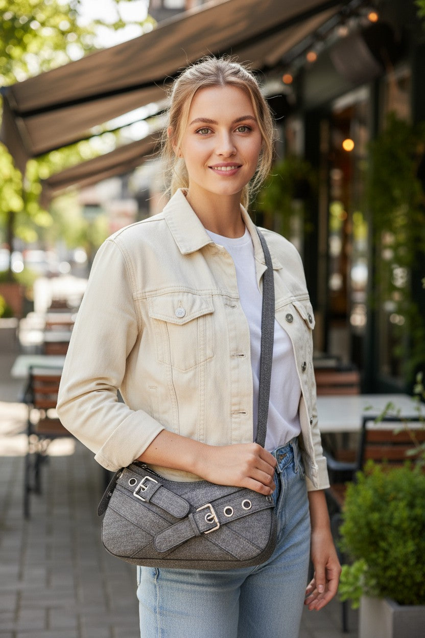 Woman holding a gray handbag outdoors in a casual setting