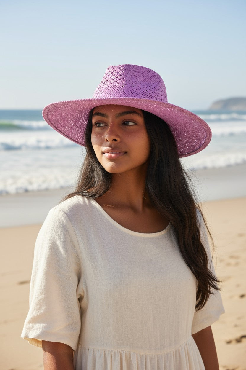 Woman wearing a purple hat on a beach