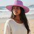 Woman wearing a purple hat on a beach