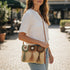 Woman holding a woven handbag with a blurred street background